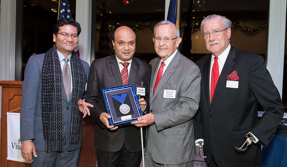 Vashkar is receiving award.