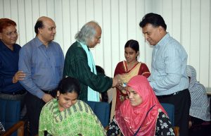 PKSF chairman handovers a phone to a woman with visually umpired student