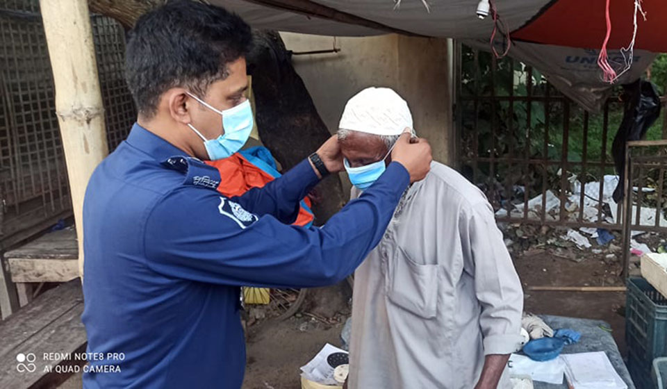 A police men helping elderly to wear mask