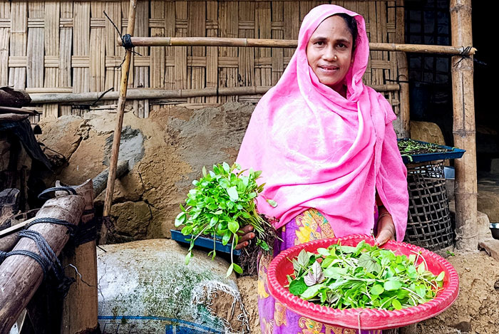A woman beneficiary with vegetable in hand 