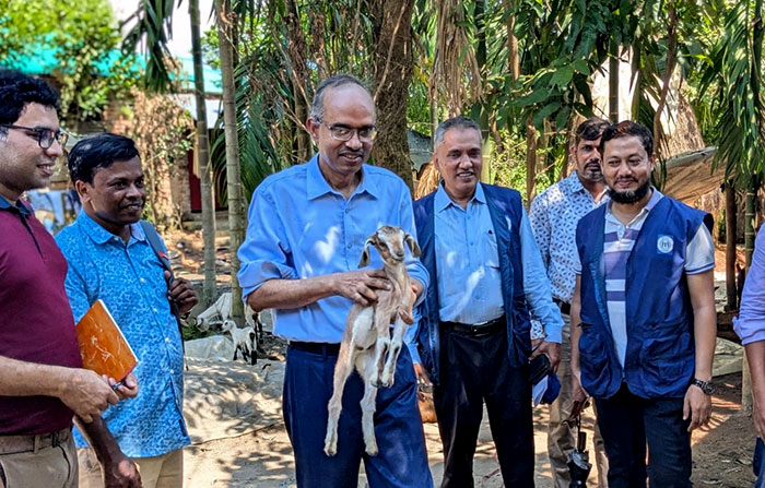 Deputy Managing Director of PKSF walking with doeling accros the village