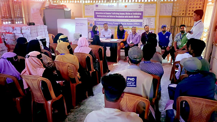 Visitors interact with Rohingya man and woman