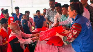 Vulnerable people receiving tarpaulins