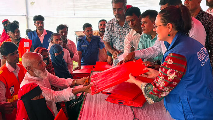 Vulnerable people receiving tarpaulins